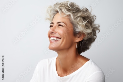 Happy smiling senior woman. Portrait of beautiful middle aged woman over grey background.