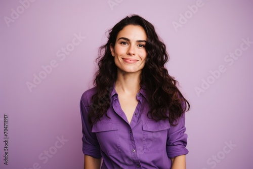 Portrait of a beautiful young woman with long curly hair on a purple background