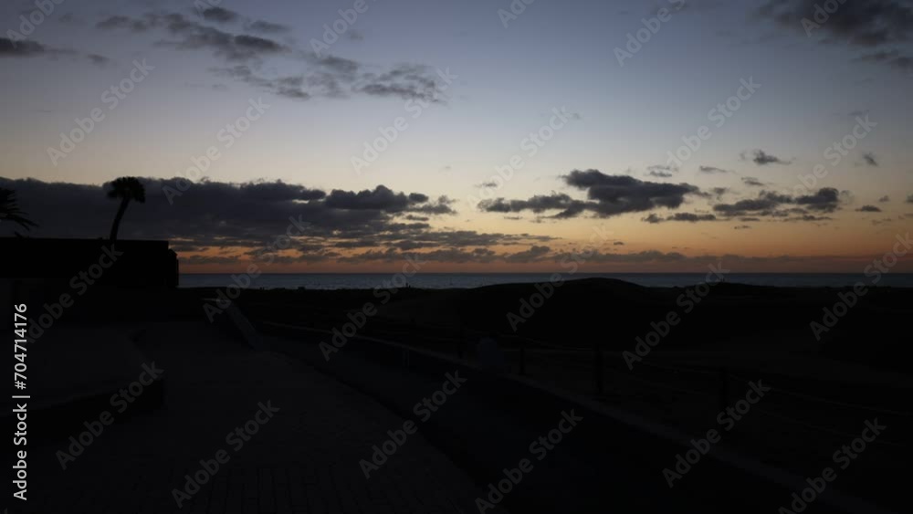 Time lapse, clouds in front of sunrise in the nature reserve Dunes of Maspalomas, Gran Canaria, Canary Islands