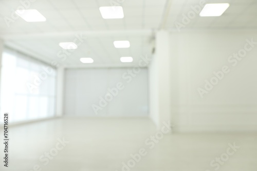 Empty room with white walls and laminated flooring, blurred view