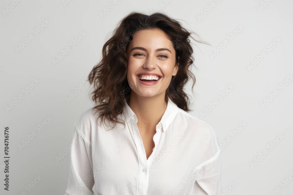 Portrait of young happy smiling woman in white shirt, over grey background Portrait of young happy smiling woman in white shirt, over grey background