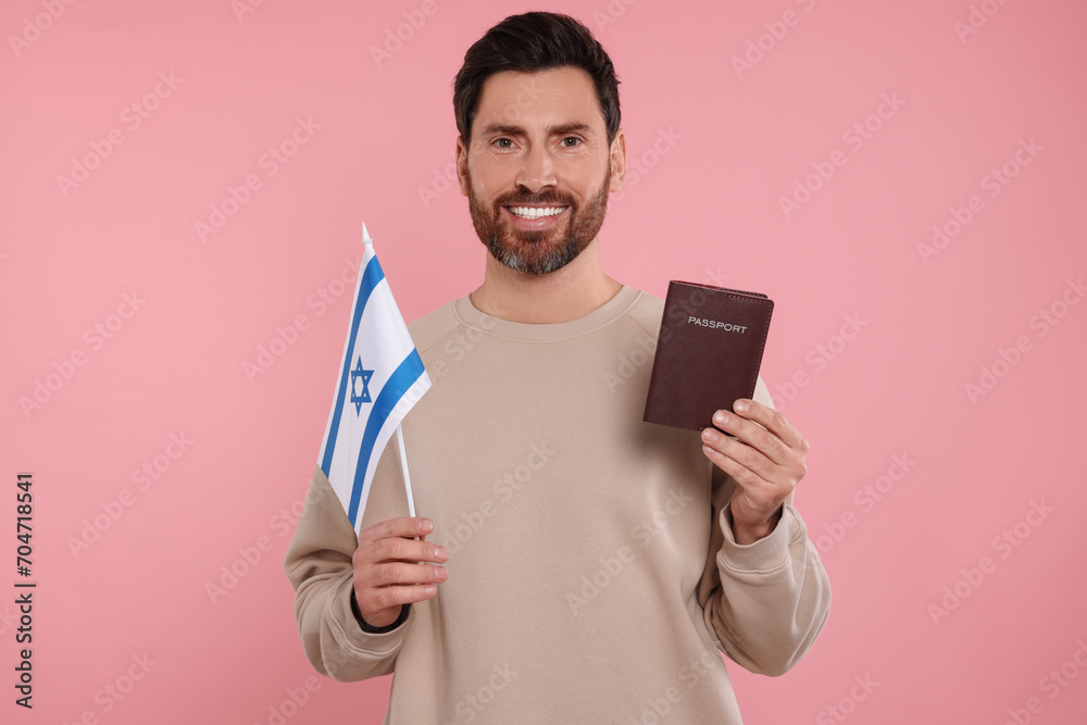 Immigration. Happy man with passport and flag of Israel on pink background Immigration. Happy man with passport and flag of Israel on pink background