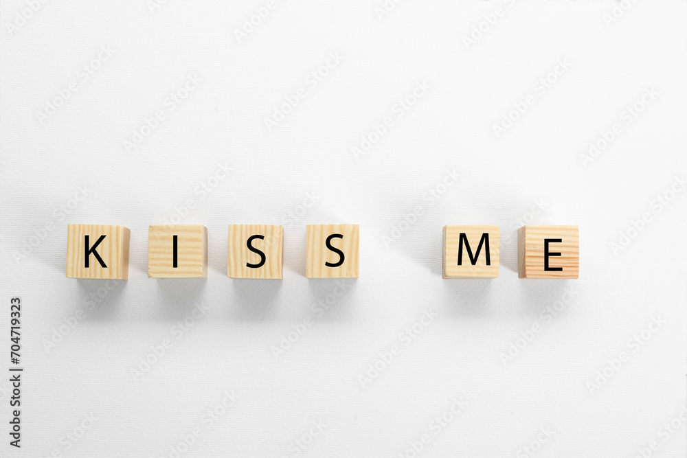 Wooden cubes with phrase Kiss Me on white background, flat lay Wooden cubes with phrase Kiss Me on white background, flat lay