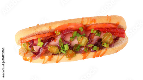 One tasty hot dog with green onion, tomato, pickles and sauce isolated on white, top view
