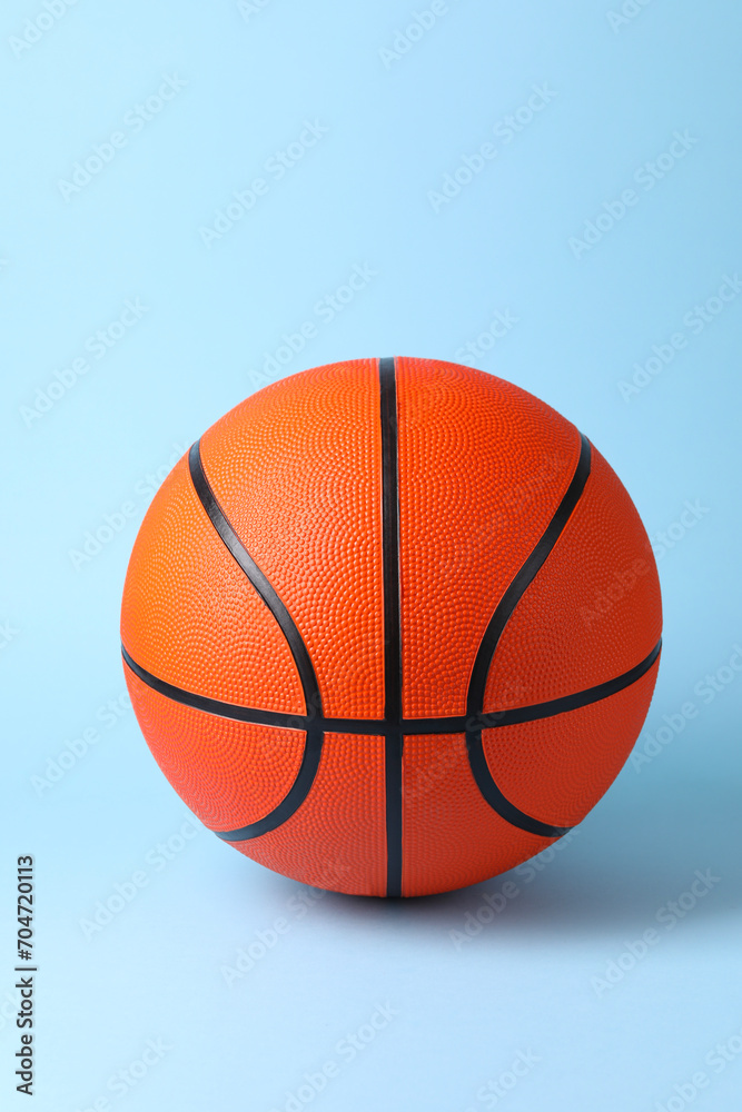 One orange basketball ball on light blue background