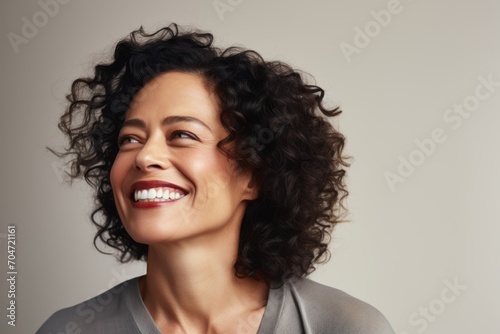 Portrait of a beautiful smiling woman with curly hair. Studio shot.