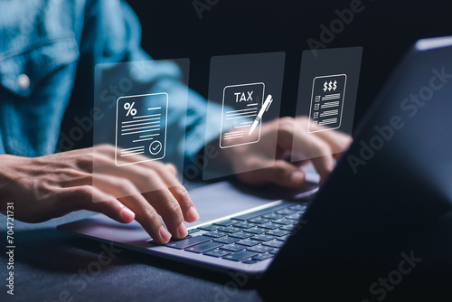 Financial research, Businessman using laptop for calculates income to pay taxes to the government. Paying taxes. Filling online tax return form for payment. Calculation tax return taxes and VAT. photo