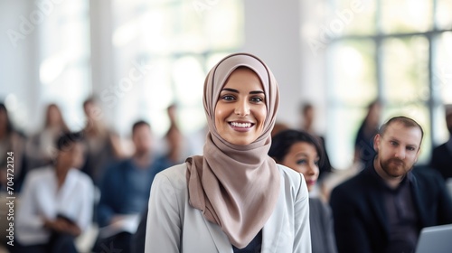 Muslim middle age business woman in front of a group 