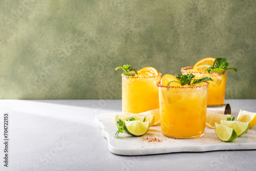 Spicy orange margarita with lime and orange slices garnished with mint photo