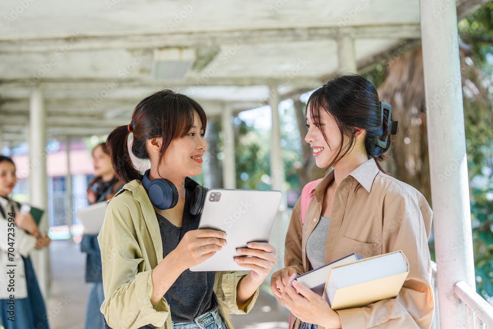 university students using a digital tablet while walking to next class. back to school concept university students using a digital tablet while walking to next class. back to school concept