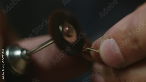 Extreme close up - a jeweler polishes a precious stone in a newly created ring photo