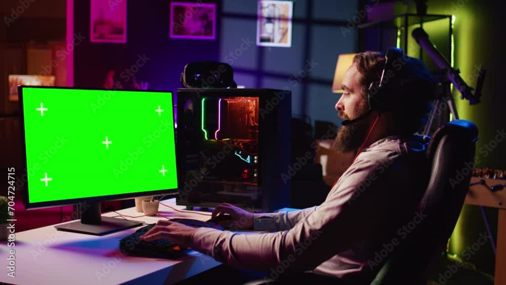 Man in dimly lit apartment playing video games on isolated screen gaming PC at computer desk, enjoying day off from work. Gamer battling enemies in online multiplayer shooter on chroma key monitor Man in dimly lit apartment playing video games on isolated screen gaming PC at computer desk, enjoying day off from work. Gamer battling enemies in online multiplayer shooter on chroma key monitor