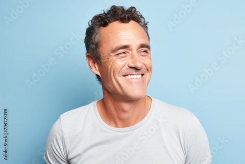 Portrait of a smiling mature man looking at camera over blue background photo