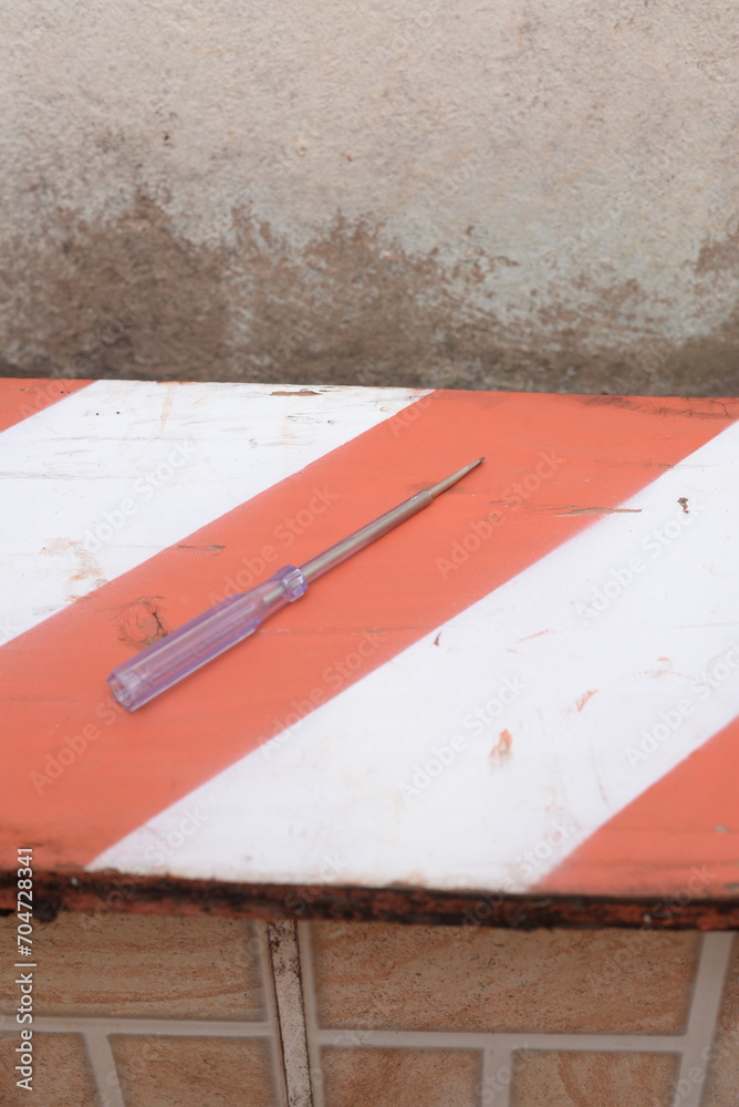 Fototapeta premium Chave de fenda translucida no quintal, matérias de construção, ferramentas