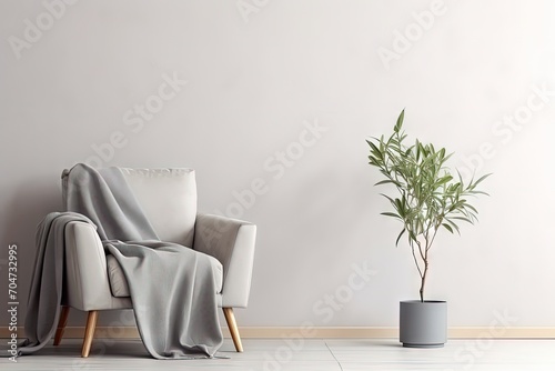 Minimalist bedroom or living room with gray modern armchair blue pillow soft blanket table pot with plant light wall in Scandinavian style