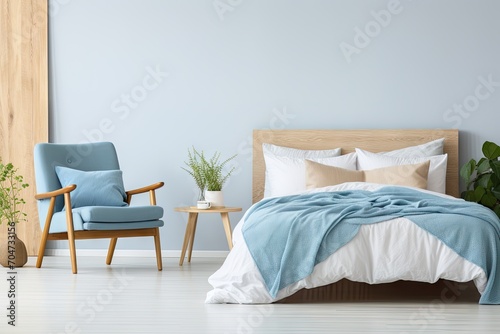 Real photo of blue pillow on white bed with wooden headboard in bedroom interior with armchair