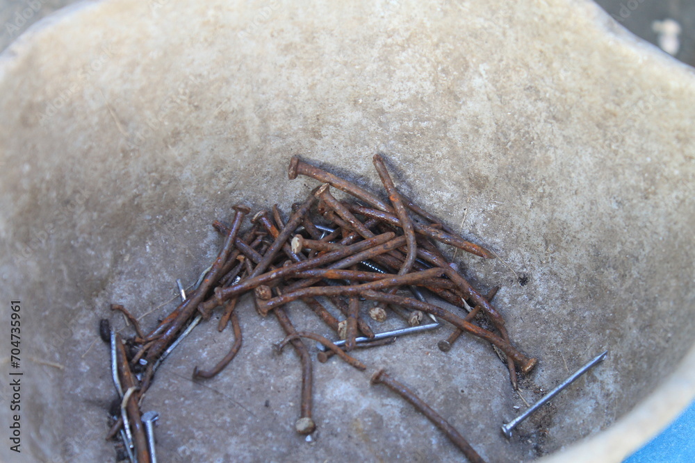 A group of rusty nails in a container