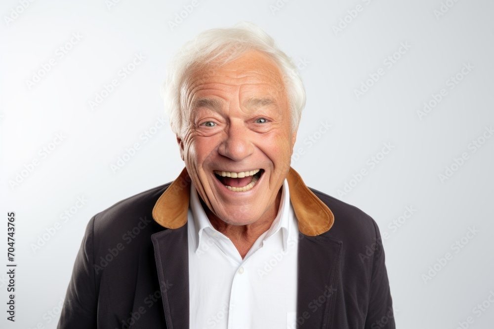 Portrait of a happy senior man laughing while standing against grey background Portrait of a happy senior man laughing while standing against grey background