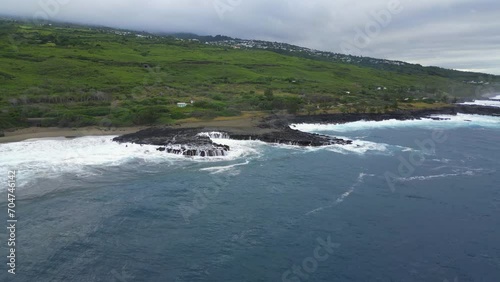 Coast and waves on volcanic rocks on a black sand beach at Reunion Island
