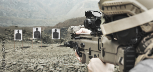 Military soldier shooter aiming ar assault rifle weapon at outdoor academy shooting range photo