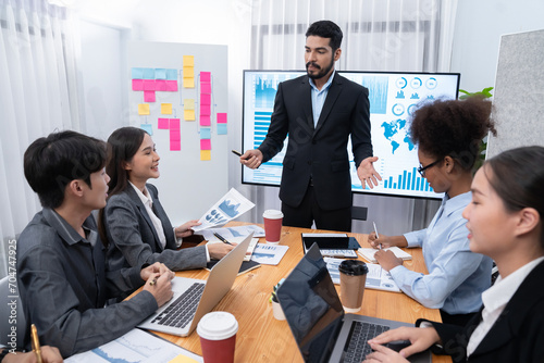 Businessman presenting data analysis dashboard display on TV screen in modern meeting for marketing strategy. Business presentation with group of business people in conference room. Concord