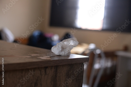 Pedra quartzo branco em cima da mesa de madeira no quarto a luz do dia photo