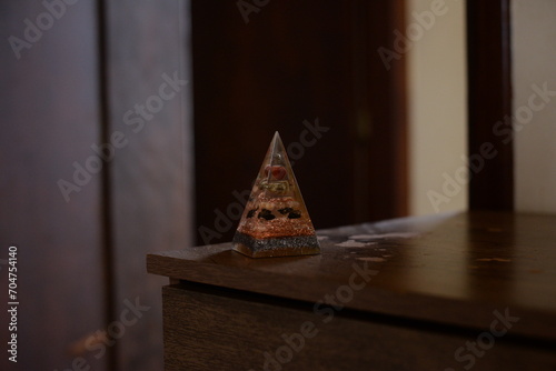 Pirâmide como peso de papel translucida em cima da mesa de madeira