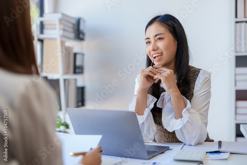 Two happy asian businesswoman talking and consulting working together in the office.