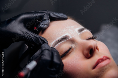 The makeup artist performs permanent makeup. Professional makeup and facial care. Eyebrow and lip tattooing. Cosmetologist. Beauty salon.