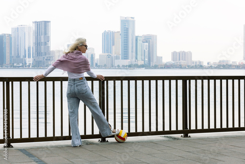 Relaxed happy woman standing on the waterfront. woman traveller on the promenade of Sarjah, UAE and  enjoying her vacation. #704761788