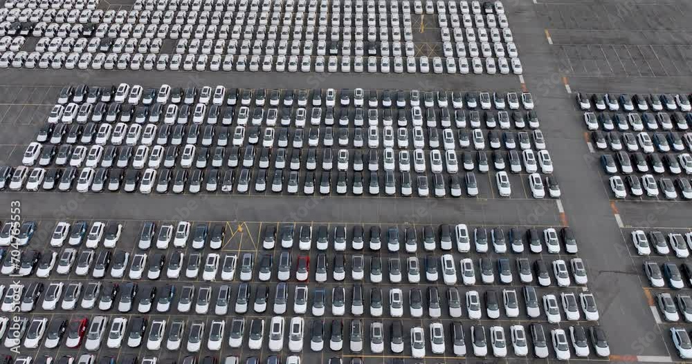 Aerial view of a new car lot, neatly arranged vehicles reflecting uniformity and precision, symbolizing organized commerce and transportation. Aerial view of a new car lot, neatly arranged vehicles reflecting uniformity and precision, symbolizing organized commerce and transportation.