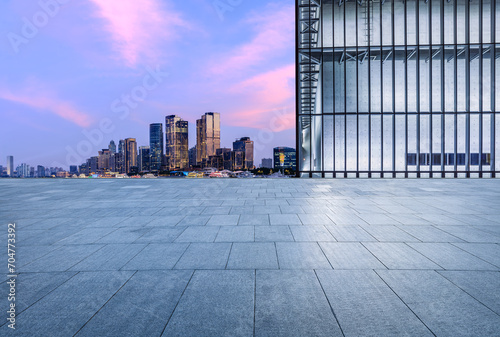 Empty square floor and glass wall with modern building at dusk in Shanghai