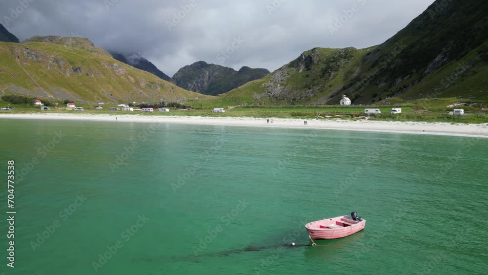 Boat floats in Arctic Sea at Haukland Beach, Lofoten Islands, Norway Boat floats in Arctic Sea at Haukland Beach, Lofoten Islands, Norway