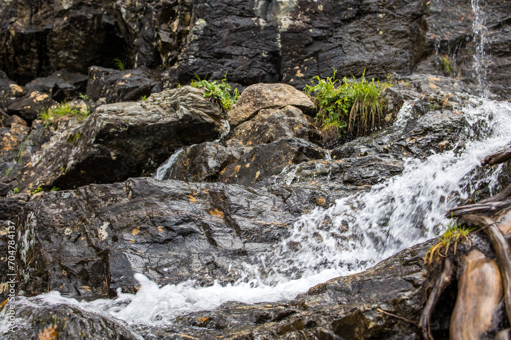 mountain stream flows over stones in a natural park