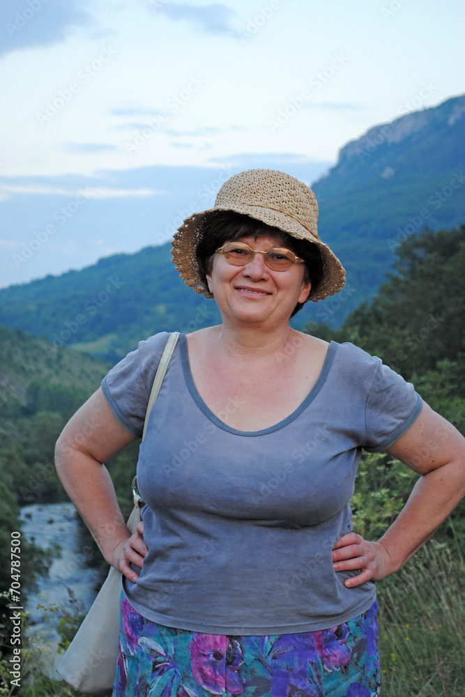 Senior happy woman traveler in the mountains