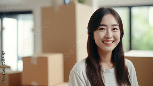 Young Asian woman smiles on her first day of moving into a house. Carrying things into the house, modern white house