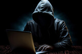 A man is sitting at a laptop on a black background. Hacking and information