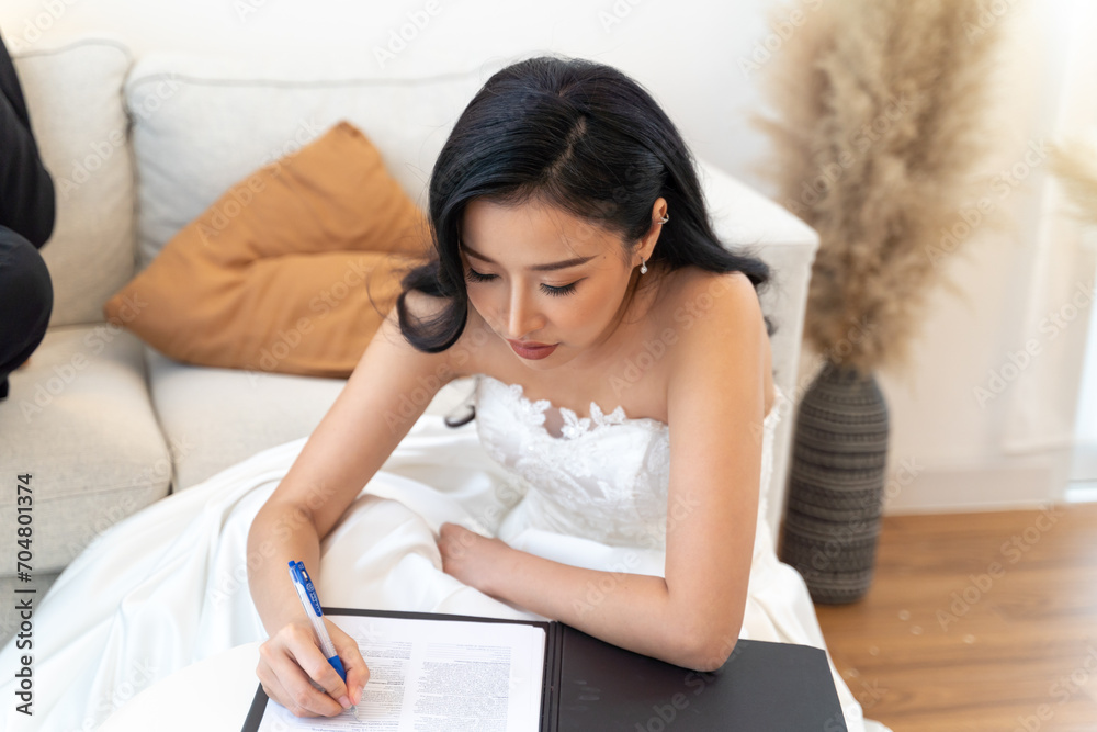 Asian woman in elegant bridal gown completing legal marriage paperwork. Bride in a white dress signs marriage documents, an official moment of commitment and beauty Asian woman in elegant bridal gown completing legal marriage paperwork. Bride in a white dress signs marriage documents, an official moment of commitment and beauty