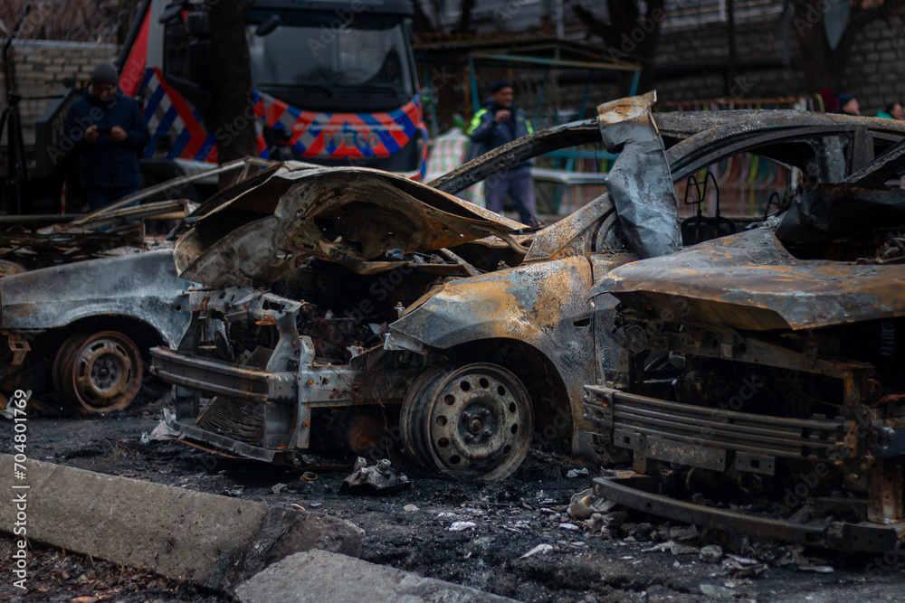 Fototapeta premium Dnepr, Ukraine – January 6: Russian drones attacked the Dnieper. Burnt and damaged cars in the Dnieper. Utility services clean up the aftermath of the attack on the city.