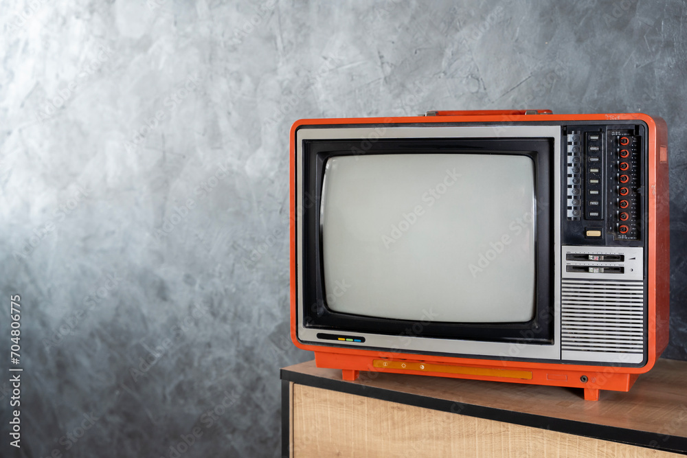 Old television concept. A vintage television set sits on a dresser in a bedroom. A retro television with a blank screen sits in a room.