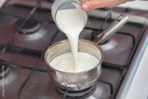Foto Boil milk in a small saucepan on the stove