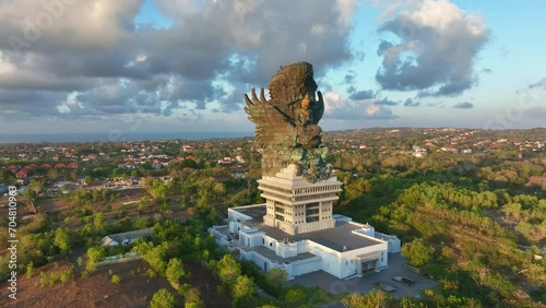 Drone video.Statue of Hindu god Garuda Vishnu Kenkhana With blue sky and clouds and sunlight in the morning located in Garuda Vesnu Kenjana Cultural Park, Bali, Indonesia. photo