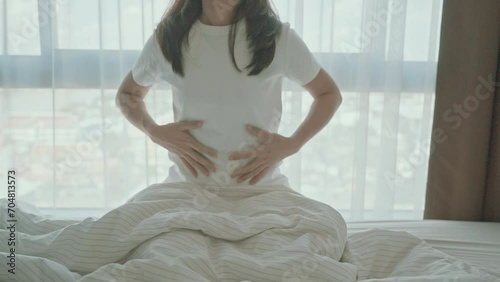 woman having abdomen ache due to Stomach pain, digestion with constipation or Diarrhea from food poisoning, female problem and Endometriosis, Hysterectomy and Menstrual on the bed at home photo