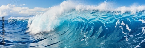 In a close-up view, surfing waves carve through the clear blue water, capturing the dynamic and exhilarating essence of the ocean's energy in vibrant detail.