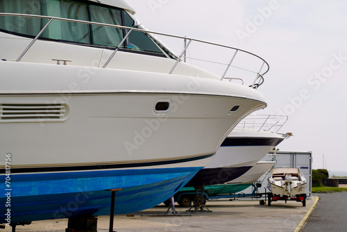 Yacht motor boats out of water hauled out in shipyard for maintenance and upkeep at the seaport before summer © OceanProd