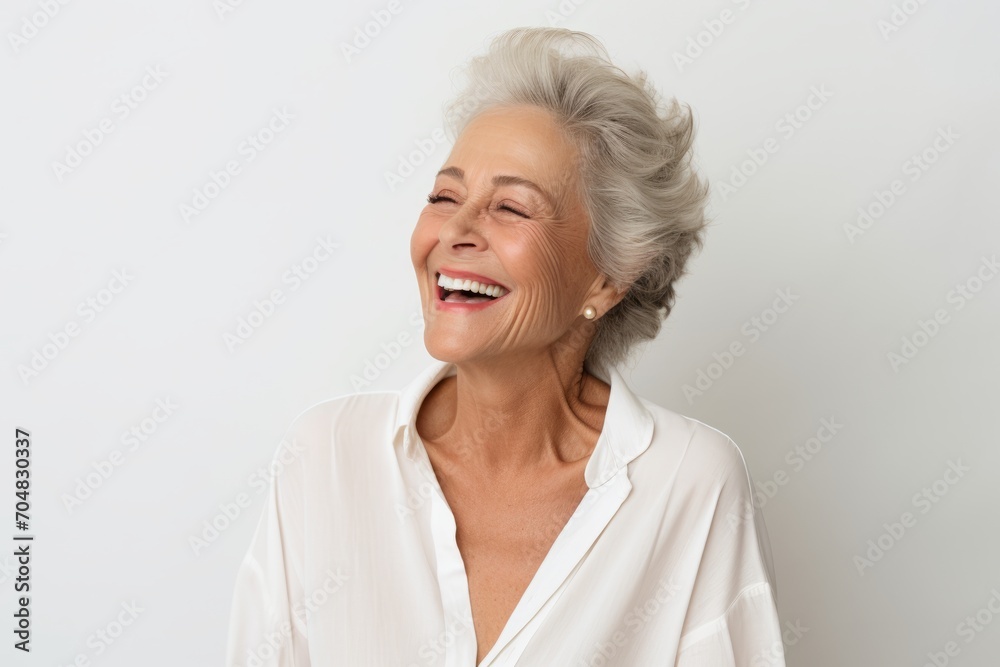 Portrait of happy senior woman laughing and looking at camera isolated over white background Portrait of happy senior woman laughing and looking at camera isolated over white background