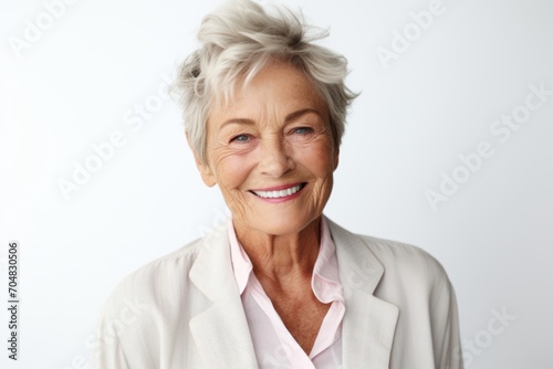 Portrait of happy senior woman with short hair smiling at camera.