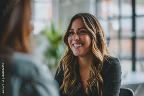 A woman smiling while talking to another woman. Generative AI.