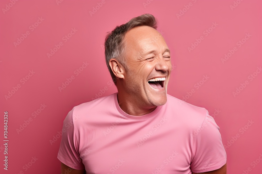 Portrait of a happy middle-aged man laughing, isolated over pink background Portrait of a happy middle-aged man laughing, isolated over pink background
