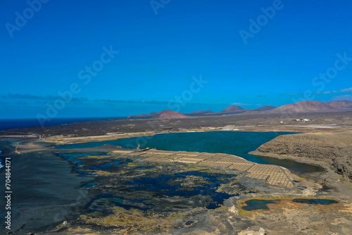 Drone panoramic view of Playa del Janubio in Lanzarote with the volcanic landscape in the background with turquoise sea and big waves. Nature and tourism. Canary Islands, Spain.